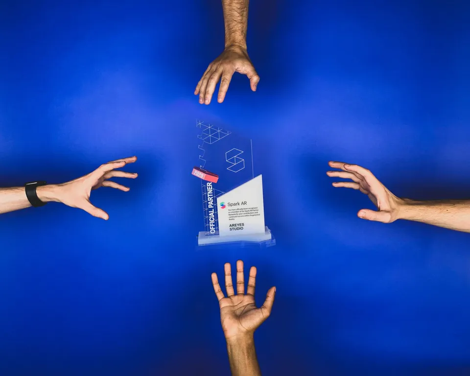 AR award trophy surrounded by hands over a blue background.